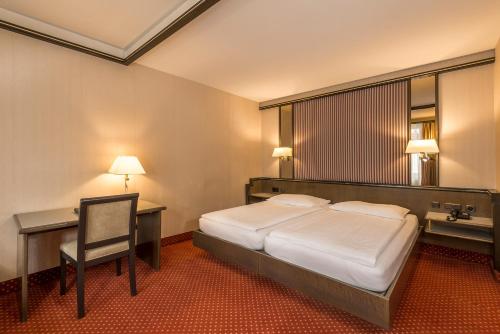 Ένα ή περισσότερα κρεβάτια σε δωμάτιο στο Hotel Monopol Luzern