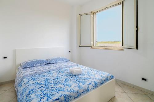 a bed in a white room with a window at La Nassa in Pachino