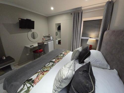a hotel room with a bed and a television at Crystal Lagoon Lodge in Langebaan
