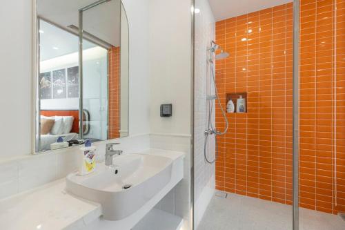 un bagno piastrellato arancione con lavandino e doccia di The Hillside a Phu Quoc