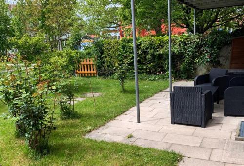 a patio with a table and chairs in a garden at H N H Ferienwohnung in Lindau