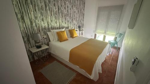 a bedroom with a large bed with yellow pillows at Balcón del Júcar delux in Tragacete