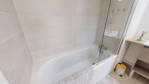 une salle de bain avec une baignoire blanche et un lavabo dans l'établissement Cap Littoral vue mer et campagne, à Saint-Gilles-Croix-de-Vie