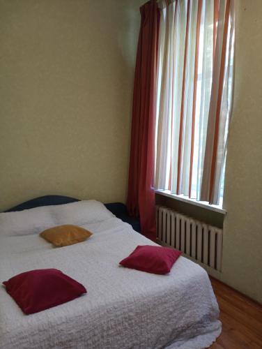 a bedroom with two pillows on a bed with a window at Welcome Apartments in Odessa in Odesa