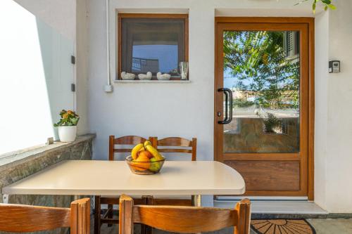 アギア・ペラギアにあるAriella, Cozy Apartment Near the Beachのドアの前に果物のボウルが置かれたテーブル