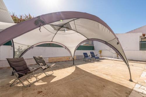 a tent with chairs and chairs under it at GuestReady - Serene Escape Close to Aroeira Beach in Lisbon