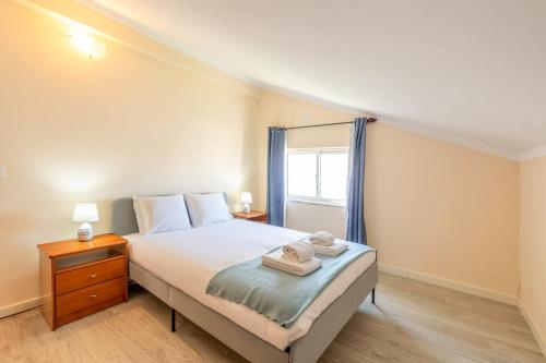 a small bedroom with a bed and a window at GuestReady - Serene Escape Close to Aroeira Beach in Charneca