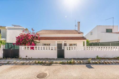 a white fence in front of a white house at GuestReady - Serene Escape Close to Aroeira Beach in Lisbon
