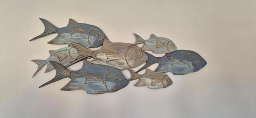 a group of blue fish decoration on a wall at Lichia Apartment in Pula