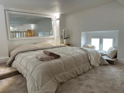 une chambre avec un grand lit avec deux serviettes dessus dans l'établissement Gaya, à Nice