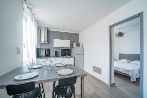 - une cuisine avec une table, des chaises et un lit dans l'établissement Villa Welcom 3 - 3min à Pied de la Plage, à Canet