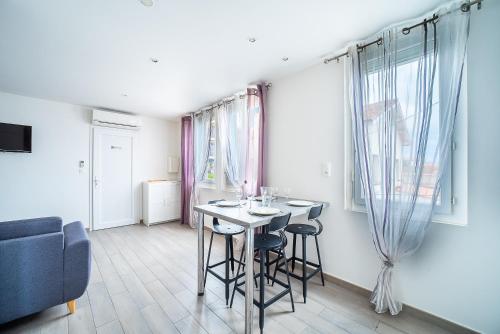 un salon avec une table, des chaises et un canapé dans l'établissement Villa Welcom 3 - 3min à Pied de la Plage, à Canet