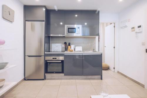 a kitchen with a stainless steel refrigerator and a microwave at 1BR hidden gem at the Nook in Gibraltar