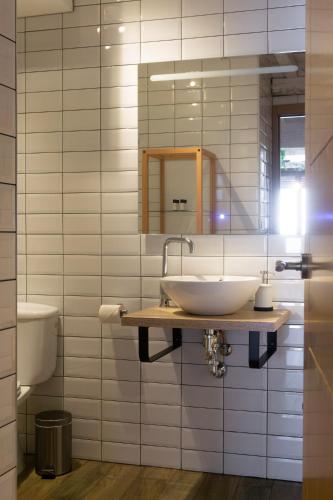 a bathroom with a sink and a mirror and a toilet at La Antigua Fonda in Hervás