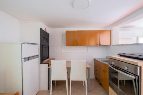 a kitchen with a table and two white chairs at Biancolino Apartments in Nardò