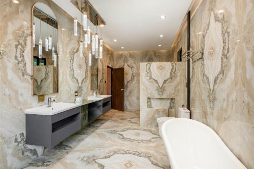 La salle de bains est pourvue d'une baignoire, de 2 lavabos et d'une baignoire. dans l'établissement Huge Pool Villa with Private Lake 4BR 10 Persons, à Ban Huai Yai