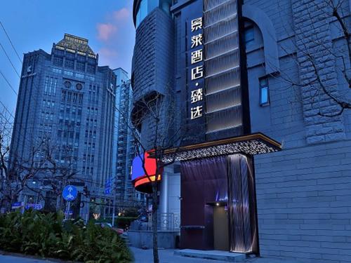 a building with a sign on the side of it at Jinglai Hotel Changshou Road Subway Station Branch in Shanghai