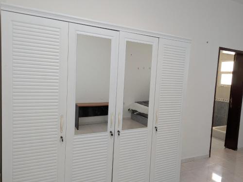a white closet with white doors in a room at Cozy Comfort Studio Central Muscat in Muscat