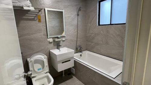 a bathroom with a toilet and a sink and a bath tub at Benz 賓士溫泉旅館 in Jiaoxi