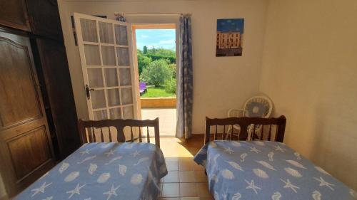 - 2 lits dans une chambre avec une porte ouverte dans l'établissement Villa les Arbousiers, à Saint-Tropez