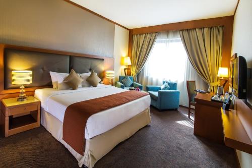 a hotel room with a large bed and a television at Landmark Summit Hotel in Dubai