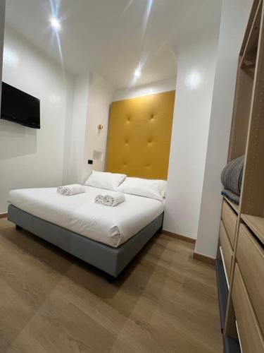 a bedroom with a bed with a yellow headboard at Hotel Ercoli House in Rome