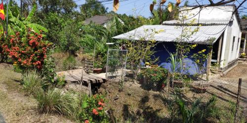 a garden with flowers and a building with a fence at Chill Guesthouse Can Tho in Can Tho