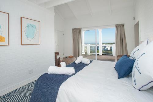a bedroom with a large bed with two pillows at Vermont Vista - With Pool in Hermanus