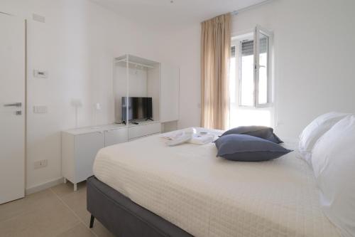 - une chambre blanche avec un lit et deux oreillers dans l'établissement Amas Loft Mascagni, à Stazione Marittima