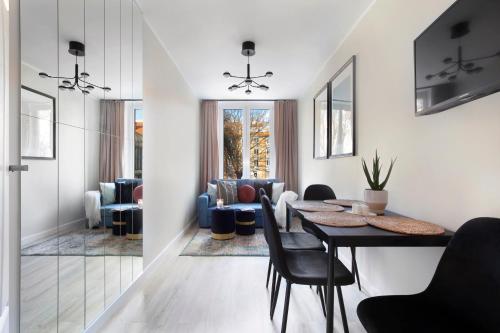 a dining room with a table and chairs and a living room at Elite Apartments Old Town Center Premium in Gdańsk