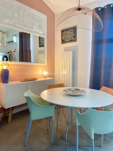une salle à manger avec une table et des chaises blanches dans l'établissement ''Zarago 3'' T3 Design en Duplex à 2 pas du centre ville, à Sète