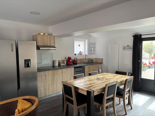 une cuisine avec une table en bois et un réfrigérateur dans l'établissement Le Fournil, à Fiennes