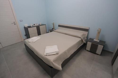 a bedroom with a large bed with towels on it at Sikelia Apartment in Favara
