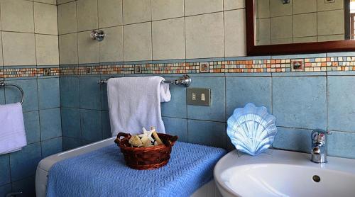 - une salle de bains avec un panier dans la baignoire à côté d'un lavabo dans l'établissement AMORE RENTALS - Villa Vanessa, à Positano