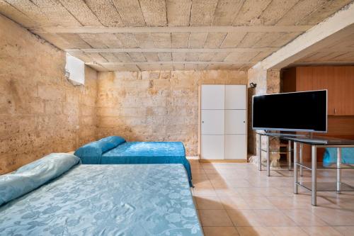 a living room with a blue couch and a flat screen tv at Biancolino Apartments in Nardò