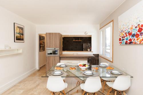 une salle à manger avec une table en verre et des chaises blanches dans l'établissement Immogroom - 2 Br - Bright - Wifi - Terrace - AC, à Cannes