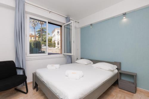 une chambre avec un lit, une fenêtre et une chaise dans l'établissement Immogroom - 2 Br - Bright - Wifi - Terrace - AC, à Cannes