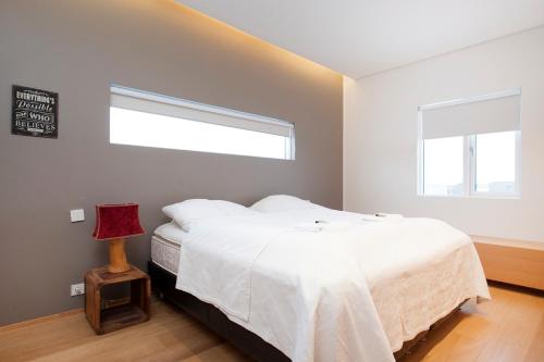 a bedroom with a white bed and a window at The Golden Circle Lodge - Luxurious villa with Sauna in Þingvellir