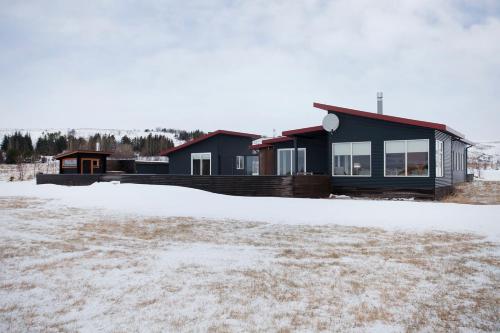 a house in the snow with a yard at The Golden Circle Lodge - Luxurious villa with Sauna in Þingvellir