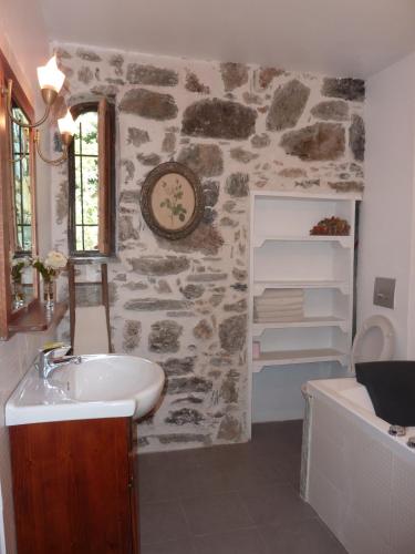 une salle de bains avec un lavabo et un mur en pierre dans l'établissement L'Olettese, à Oletta