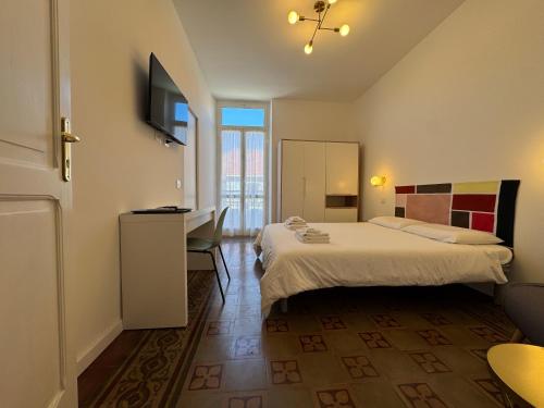 a hotel room with two beds and a desk at Noliday Savona Center Art Deco Apartment in Savona