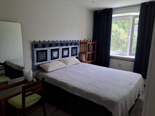 a bedroom with a bed with a blue headboard and a window at Virmalise 5 in Tallinn