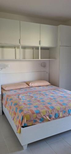 a bed with a colorful comforter in a bedroom at Casa Capinera in Pula