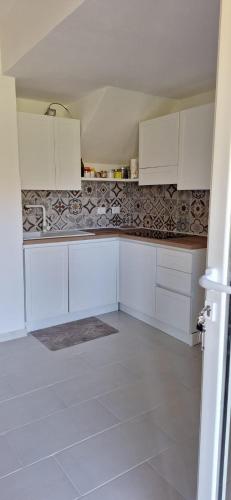 a kitchen with white cabinets and a tile floor at Casa Capinera in Pula