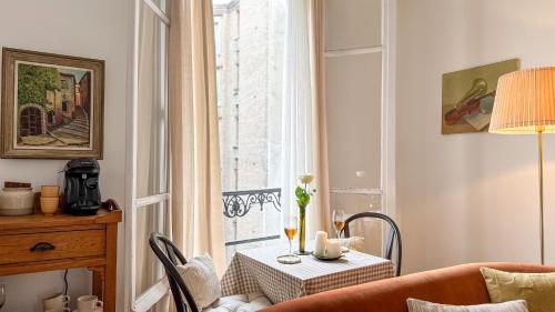 un salon avec une table et une fenêtre dans l'établissement Le Repaire Tranquille, à Paris