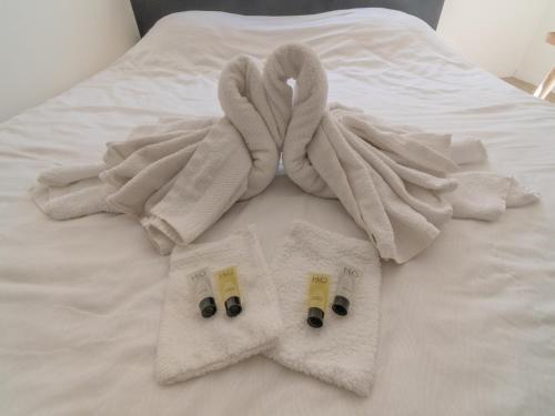a bed with two towels and two pairs ofippers at Holiday Home in La Roche near Center in La Roche-en-Ardenne