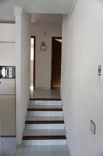 a hallway with stairs leading to a kitchen and a door at Le Silence in Roses