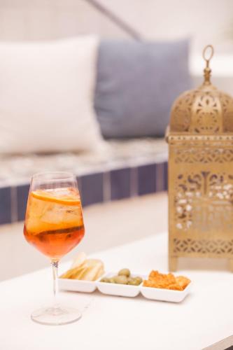 a drink in a glass next to a plate of food at Le Porte del Tempo in Mazara del Vallo