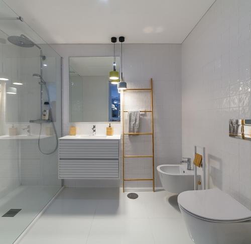 a bathroom with a sink and a toilet and a tub at Lina Beach Villa by Home Sweet Home Aveiro in Praia da Barra