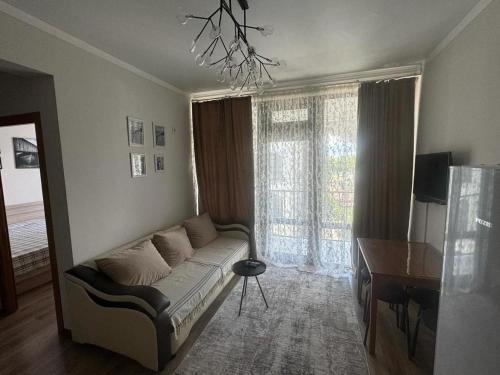salon z kanapą przed oknem w obiekcie ЦО Радуга плюс w mieście Akchiy